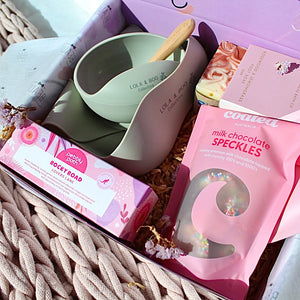 Close-up of Lola & Boo silicone feeder and lip balm in soft pastel tones