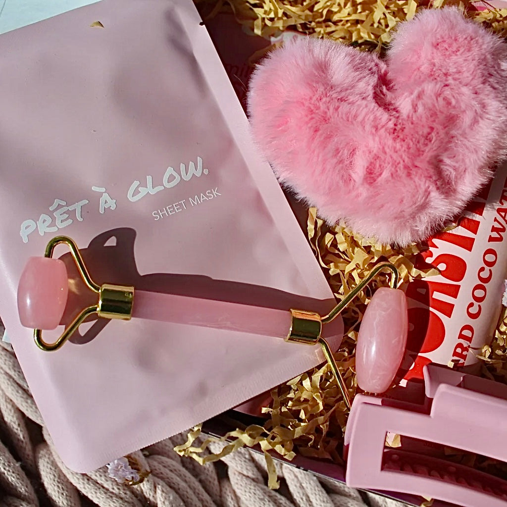 Beaut Box with Pamper & Self-Care Products for Women including a soap, chocolate bag, candle, hair claw, keychain, face mask, face roller, coconut water, bag, and rocky road treat