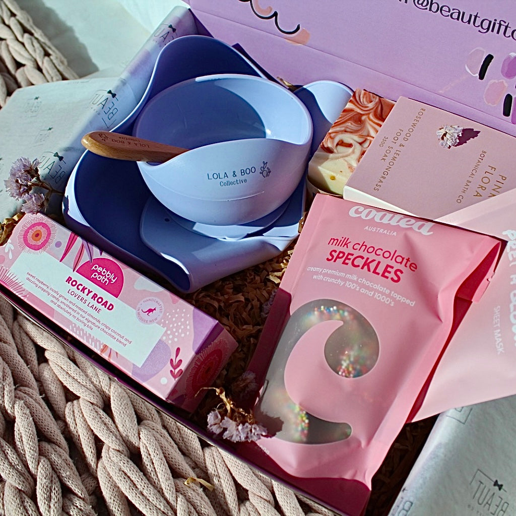 Mum and Bub Beaut Box with baby feeder, treats and skincare items displayed beautifully