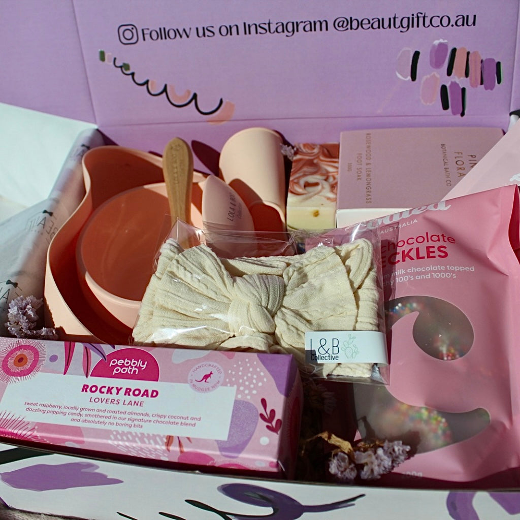 Mum and Bub Beaut Box with baby feeder, treats and skincare items displayed beautifully