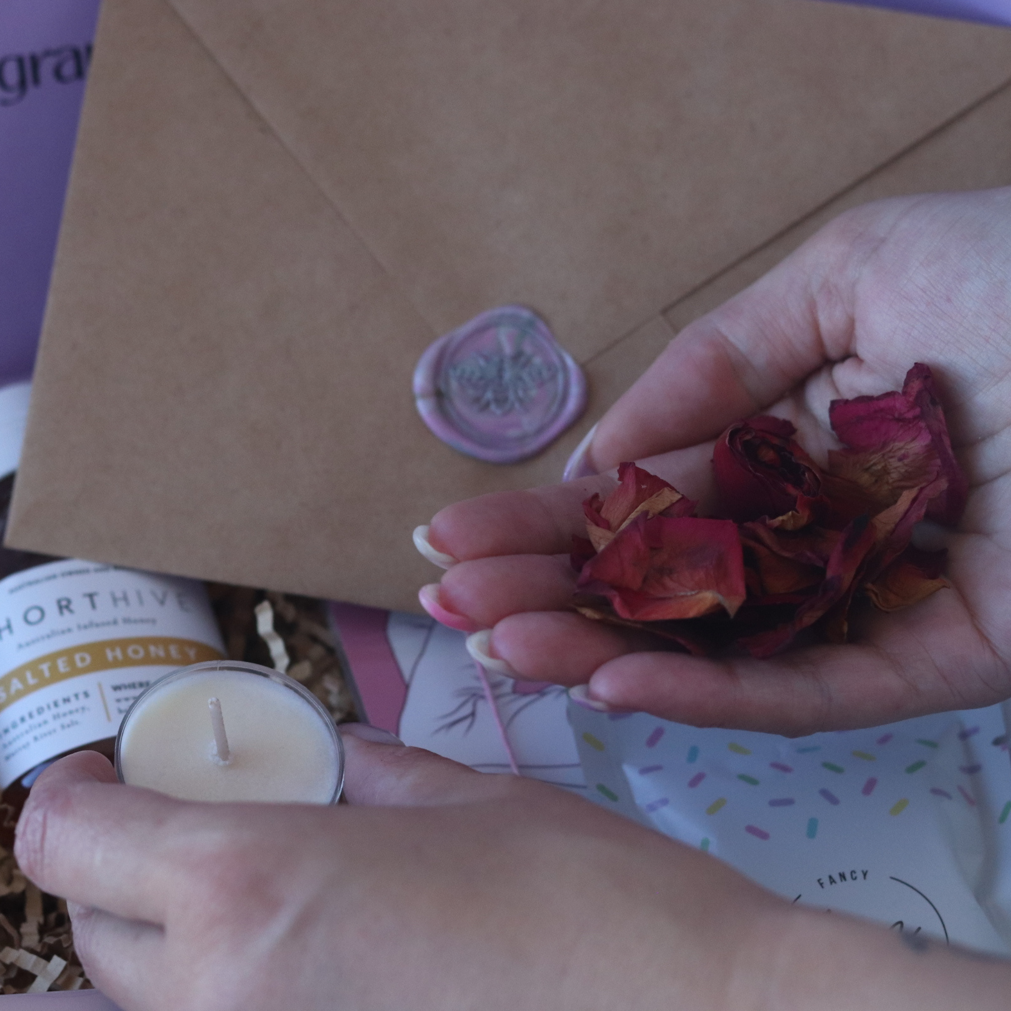 wax seal stamp being poured plus candle and flower petals