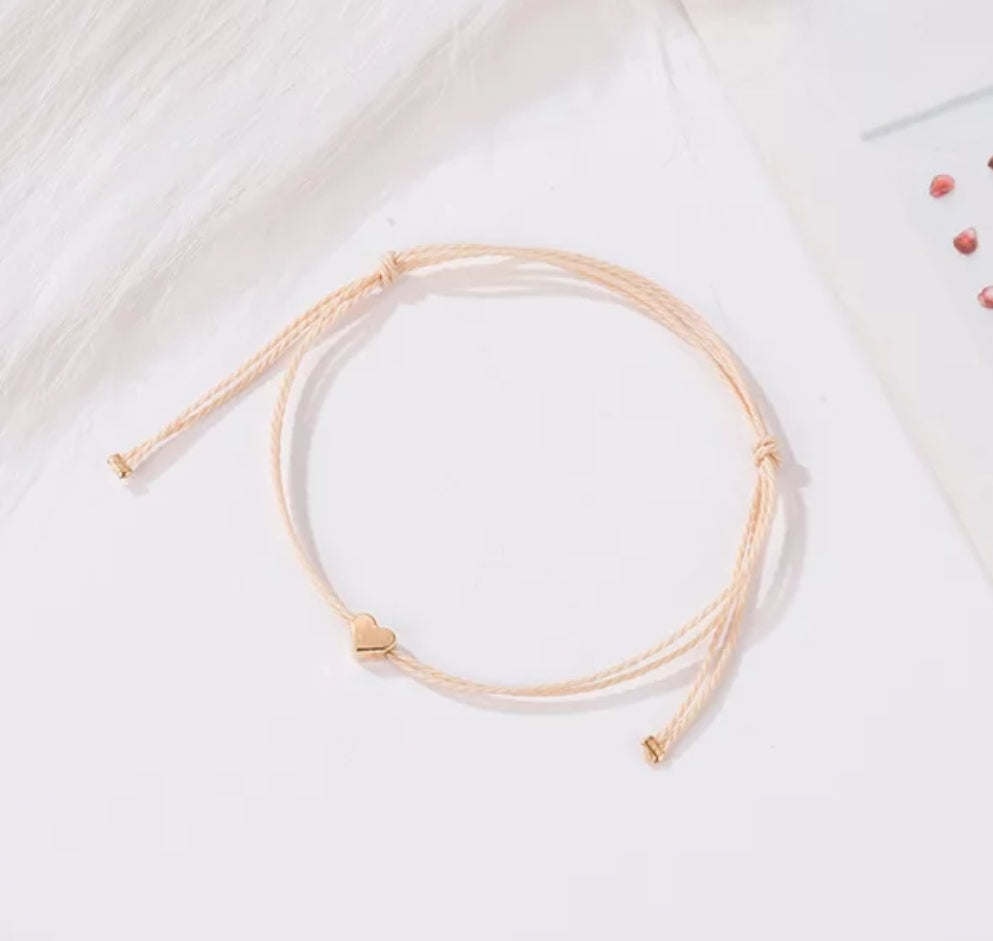 minimalist bracelet with rose gold heart and cream thread