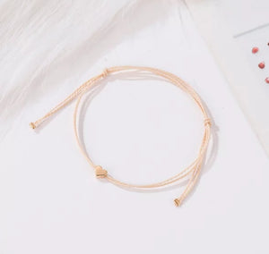 minimalist bracelet with rose gold heart and cream thread