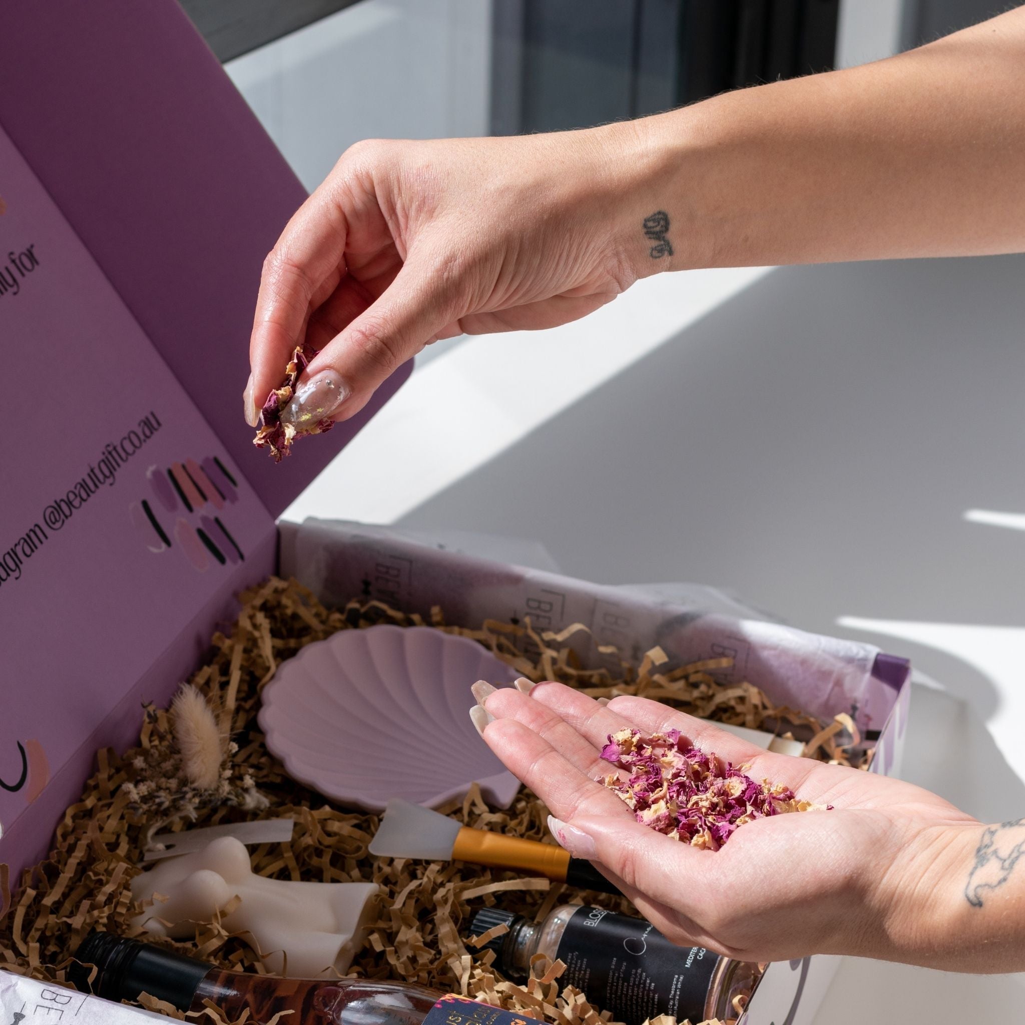 sprinkling flower petals to decorate a beaut box
