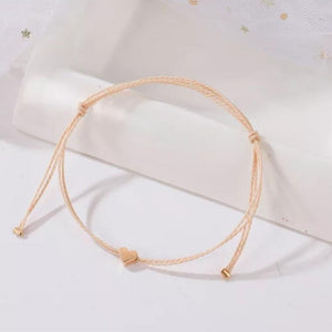 minimalist bracelet with rose gold heart and cream thread